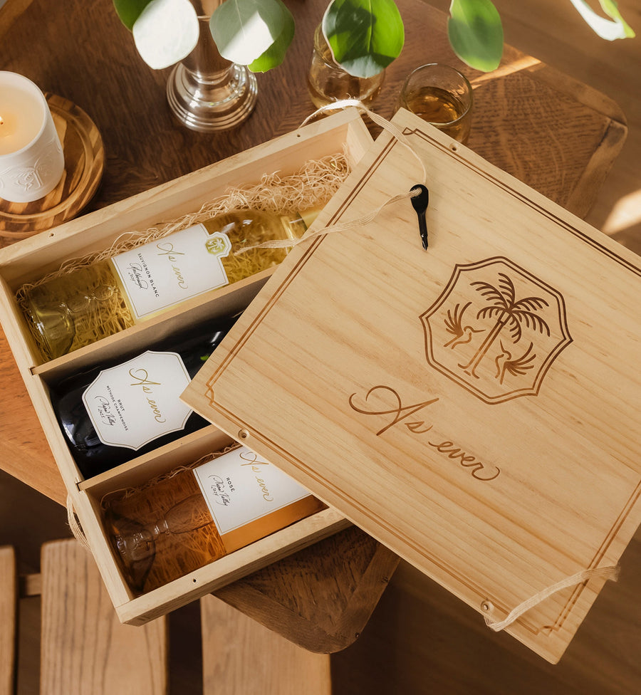 As ever wooden crate with engraved As ever logo and wine bottles inside on a wooden table